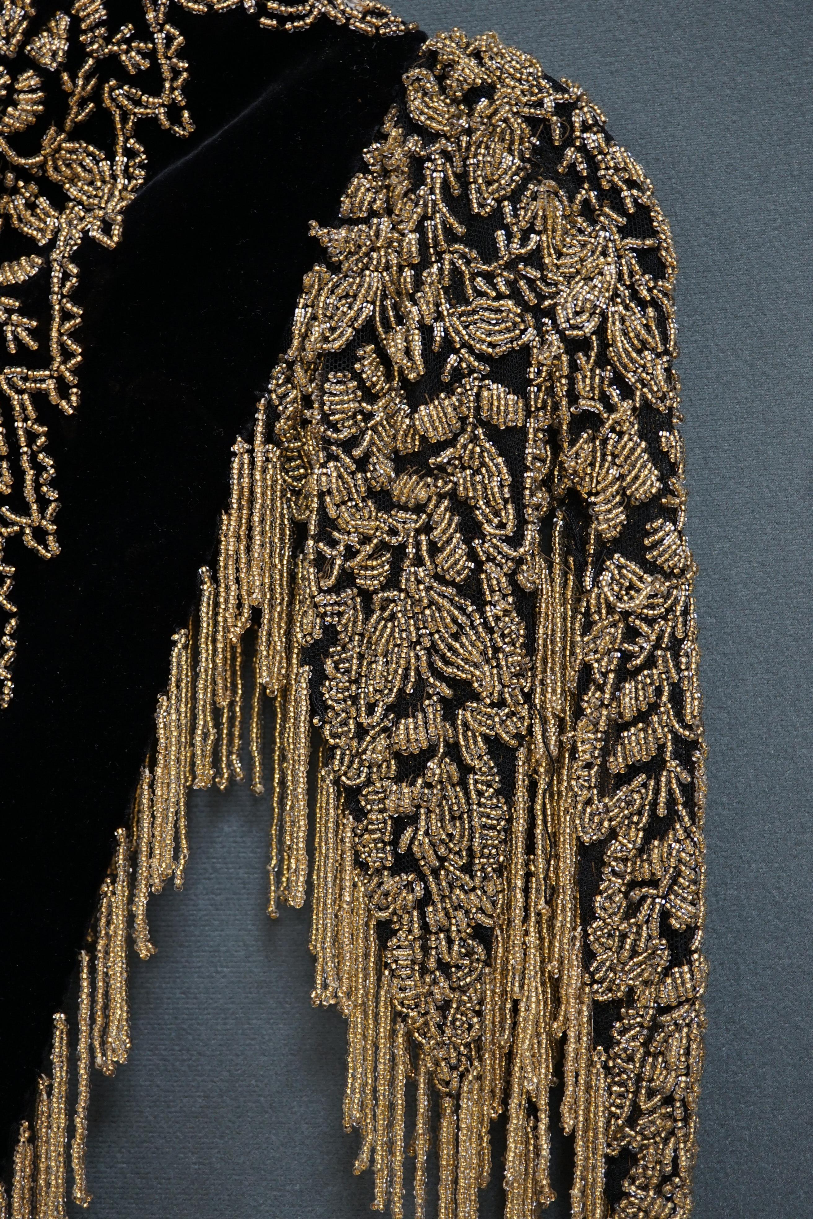 An Edwardian French black velvet and elaborately beaded evening over collar, with makers label, ‘Fillet’, designed with a high collar, front and back panels, all heavily bead worked in an intricate floral design, attache